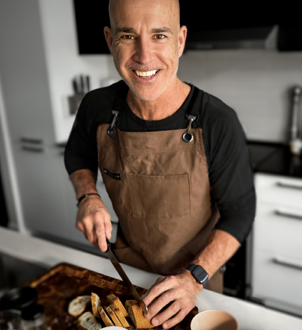 Chef Nico slices baguette in the white and black kitchen