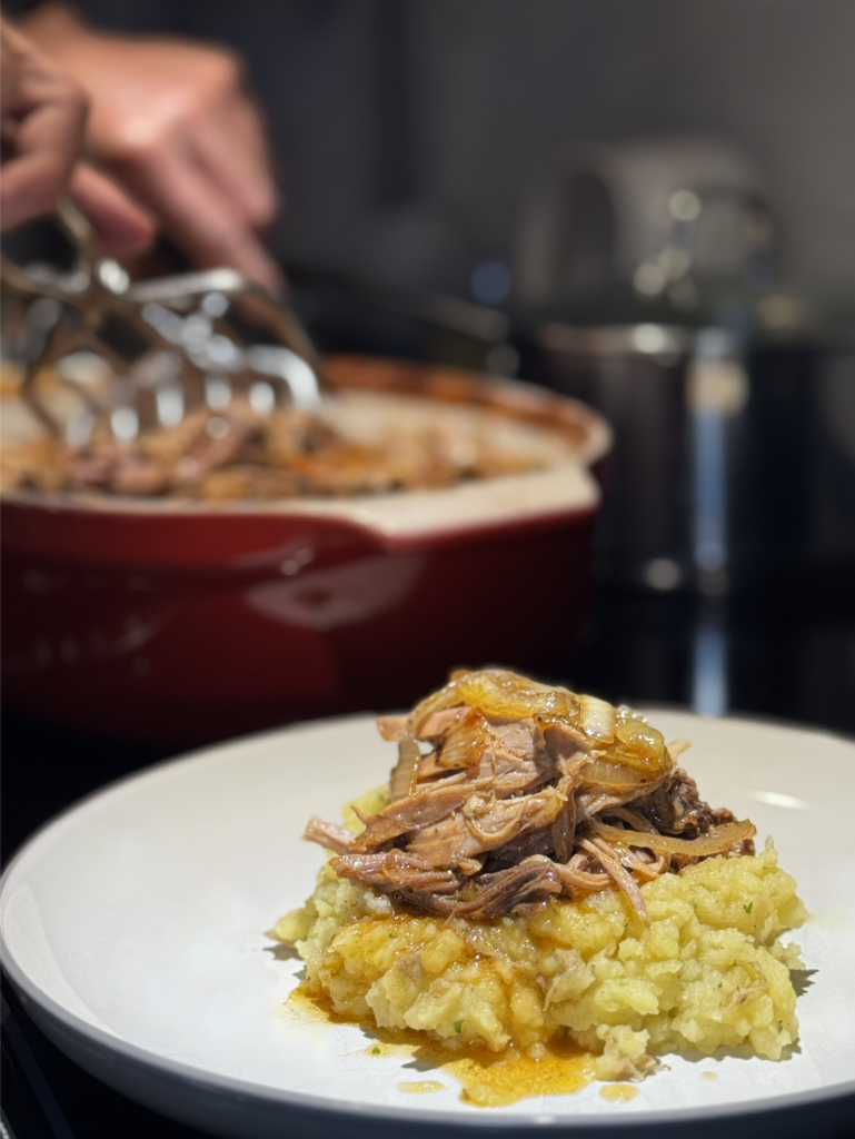 Chef Nico in background makes pulled pork and plates it over mashed potatoes