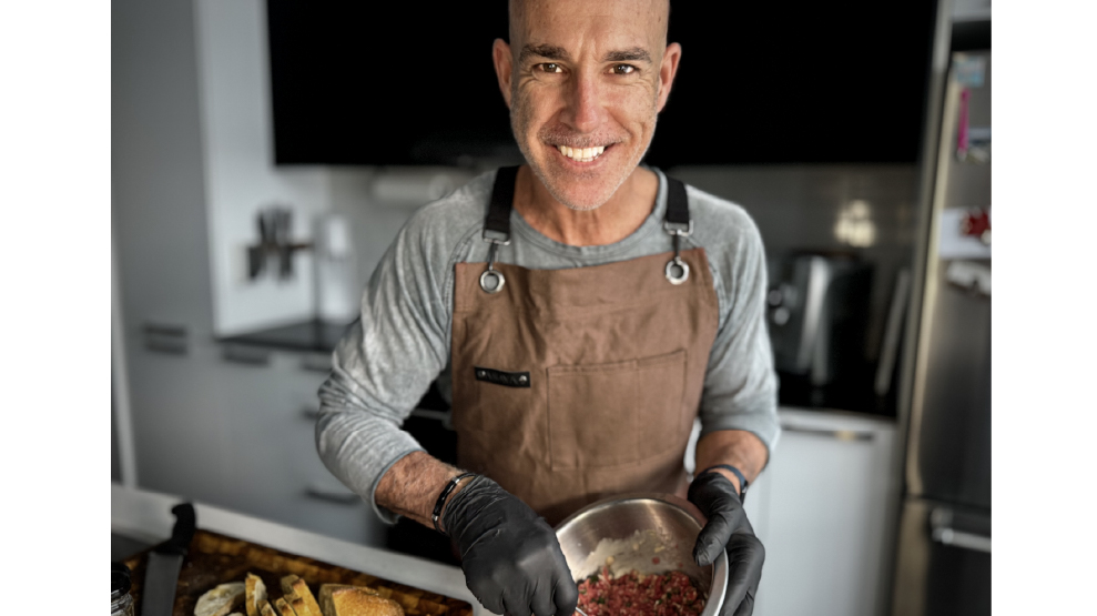 Chef Nico looks right into the camera as he mixes meat in a bowl