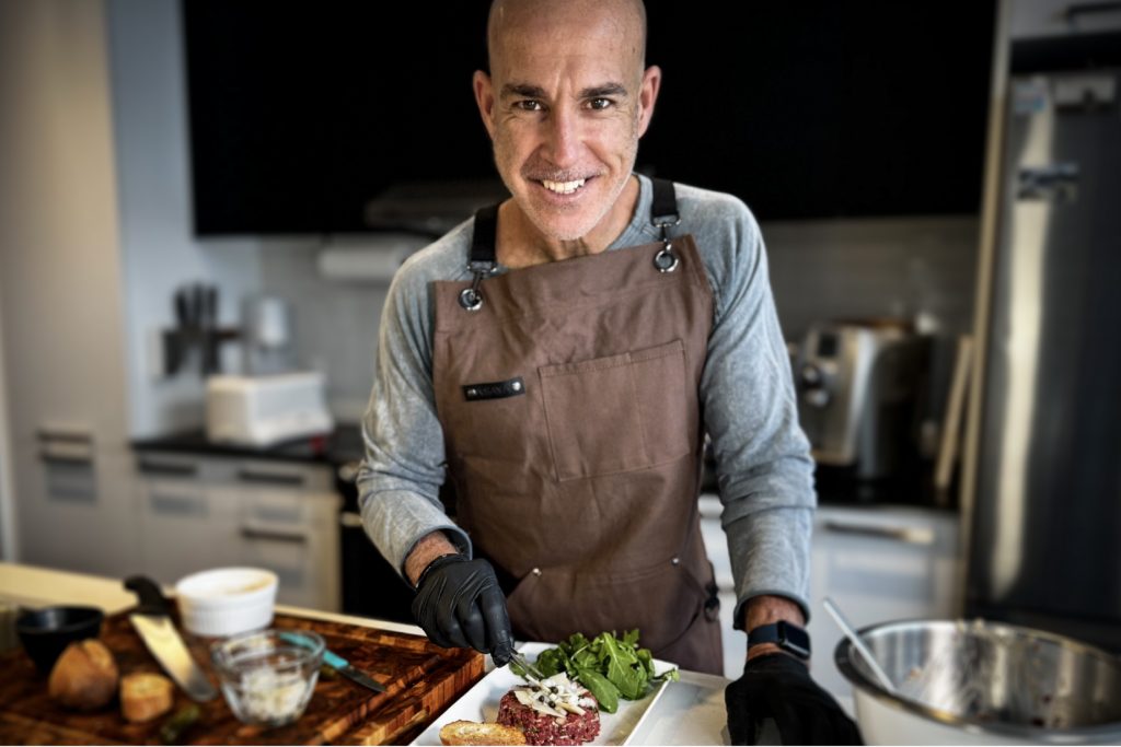 Chef Nico prepares steak tartar in a white kitchen